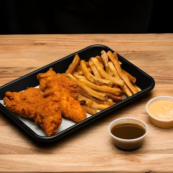 Halal chicken tenders and fries with two dipping sauces on a black tray on a wooden table.